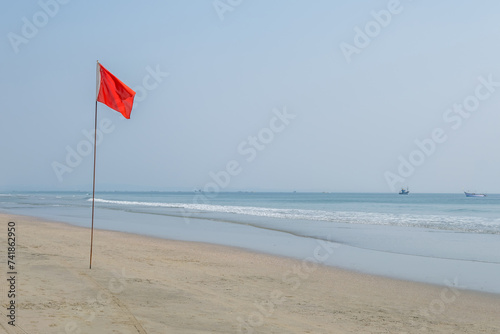 red flag on beach on sea or ocean as a symbol of danger. The sea state is considered dangerous and swimming is prohibited. photo