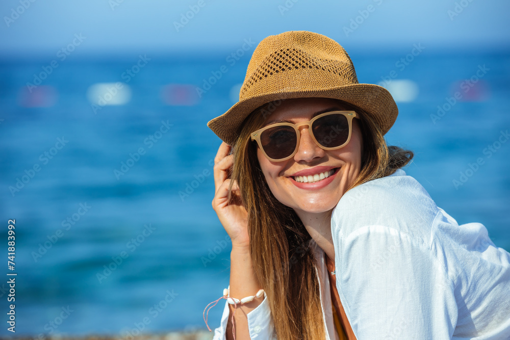 Young beautiful woman with sunglasses laying at the beach.