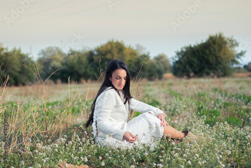 Mujer vestida de blanco en un prado de flores blancas