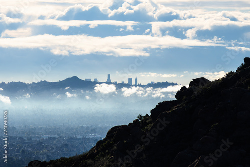 Downtown Los Angeles towers peaking over Santa Monica Mountains ridge with clearing storm clouds.  Photo taken in Rocky Peak Park in Chatsworth California. photo