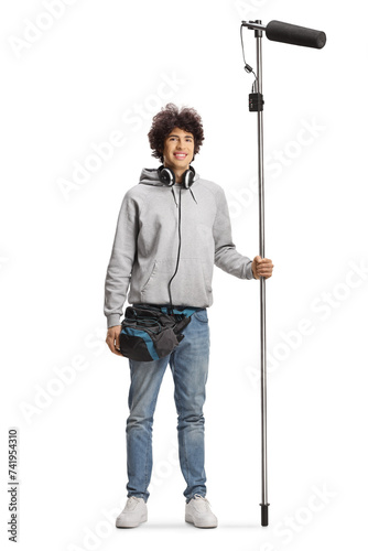 Boom operator with headphones holding a microphone and smiling at camera