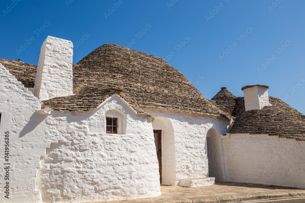 Alberobello Italy - traditional trulli houses with conical stone roofs. Famous landmark, travel destination and tourist attraction near Bari in Puglia, Europe. Old Mediterranean architecture.