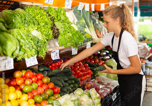 Obraz na plátně Focused fifteen-year-old girl who works part-time in a store as a trainee salesw