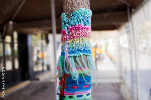 Yarnbombing, trees decorated with yarn bombing, knitted graffiti street art, kniffiti in the european city, colored urban knitting, process of graffiti knitting and creating guerilla knitting photo