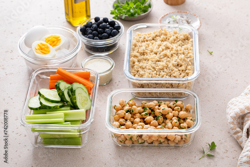 Meal prep containers with healthy food prepped, cooked quinoa, chickpeas and eggs