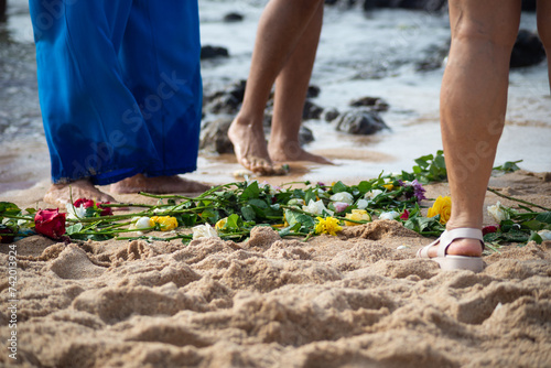 Lower part of the legs of unidentified people wet in the beach water. photo