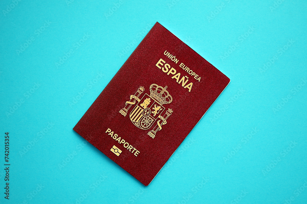 Red Spanish passport of European Union on blue background close up. Tourism and citizenship concept Red Spanish passport of European Union on blue background close up. Tourism and citizenship concept