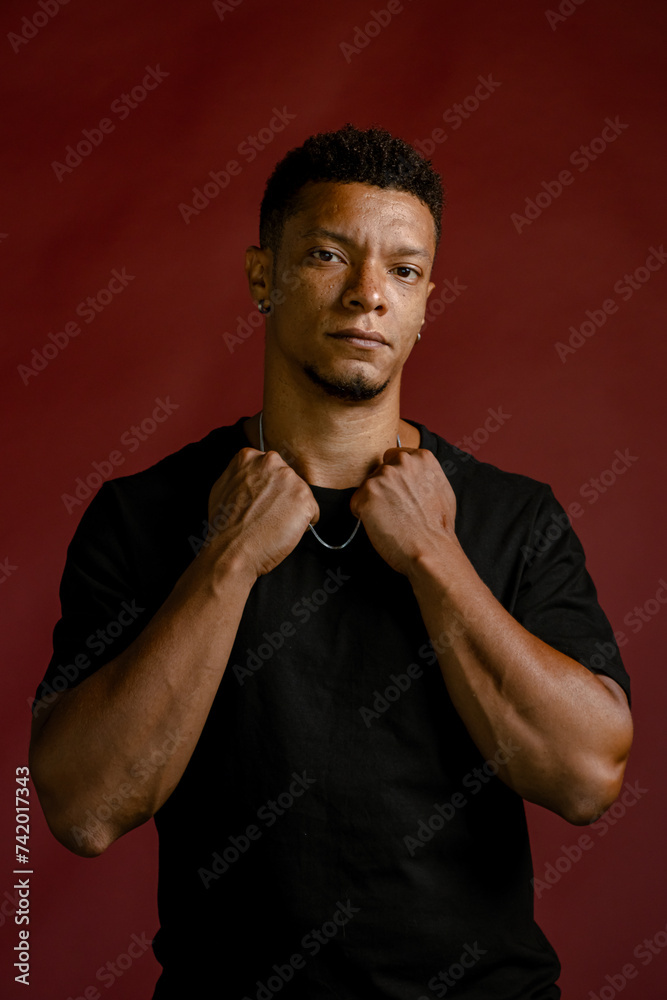 Portrait young African man looking serious with red background