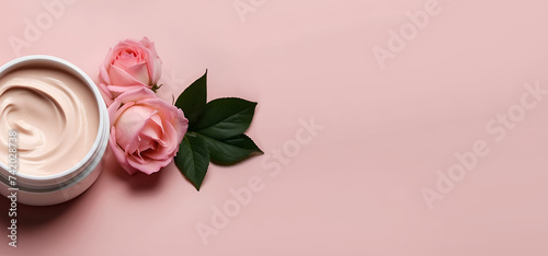 Un pot de crème de beauté ouvert pour le soin du visage avec des fleurs sur un fond rose photo