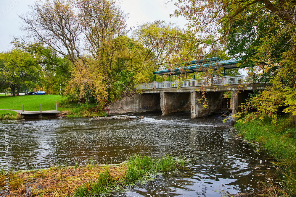 Fototapeta premium Accessible Bridge over Creek in Autumn Park, Overcast Day