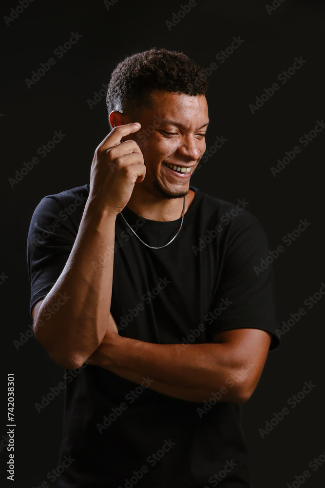 Portrait of young African man smiling with black background