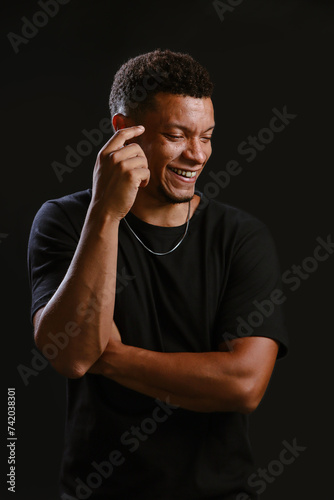 Portrait of young African man smiling with black background