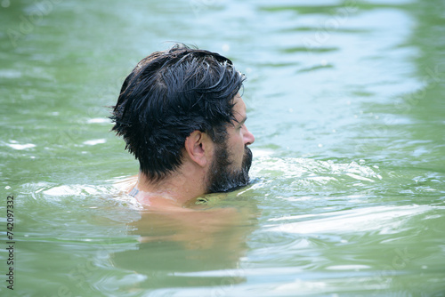 Man swimming in water. Swimmer swim concept. Summer time lake.