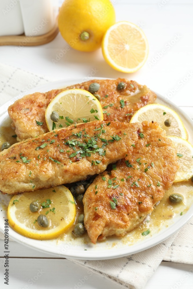 Delicious chicken piccata on white table, closeup