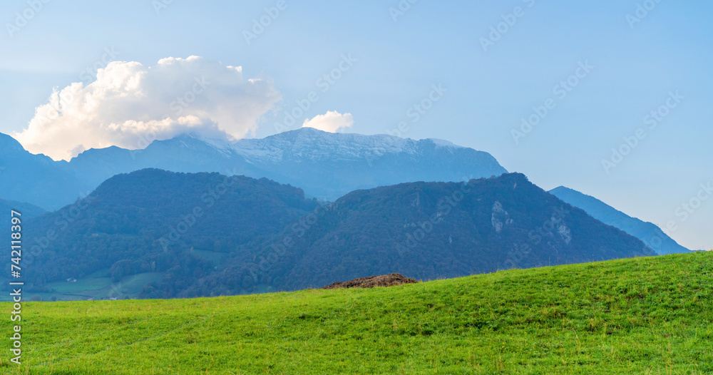 Beautiful landscape of the layered misty hazy Italian Alps mountain range during evening. Alpine summer sunrise. Lombardy, Italy Beautiful landscape of the layered misty hazy Italian Alps mountain range during evening. Alpine summer sunrise. Lombardy, Italy