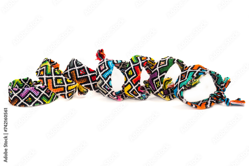 Multicolored woven DIY friendship bracelets handmade of embroidery bright thread with knots isolated on white background