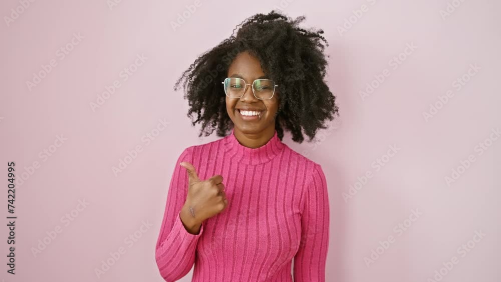 Happy african american woman in glasses standing, showing a thumbs up gesture of success! looking approving and cheerful over pink, she's a winner! Happy african american woman in glasses standing, showing a thumbs up gesture of success! looking approving and cheerful over pink, she's a winner!