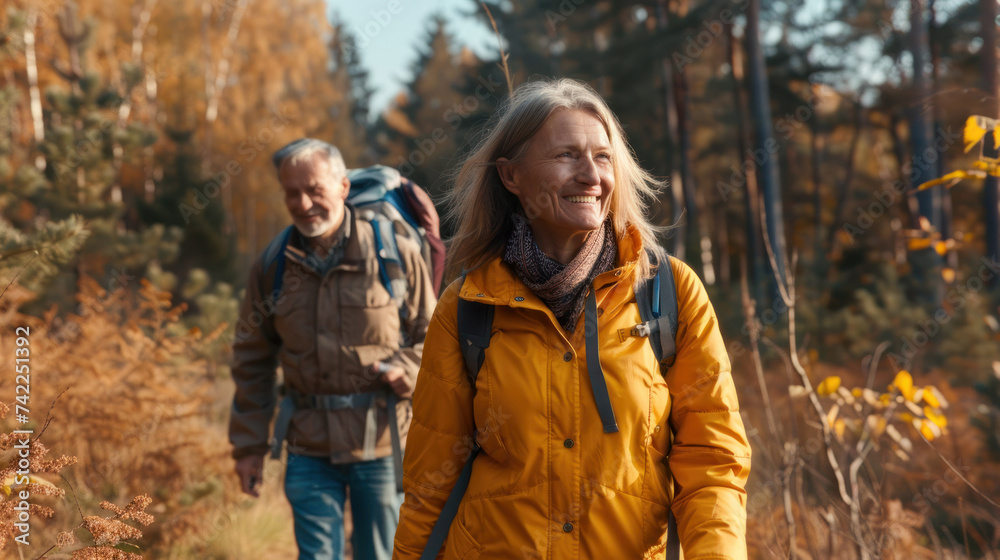 Portrait cheerful smiling middle age woman hiking walking with her husband enjoying free time and nature. Active beautiful seniors in love together at sunny day