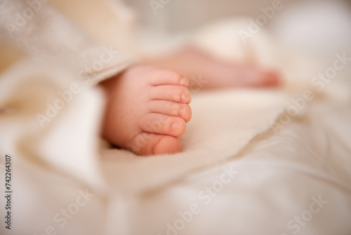 Baby, feet and toes or blanket as closeup for childhood development or nursery sleeping, relax or resting. Kid, wellness and childcare on bed for wellbeing nap or dreaming nurture, caring or calm photo