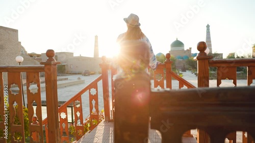 Tourist woman in ethnic dress near mosque in Ichan Kala of Khiva photo
