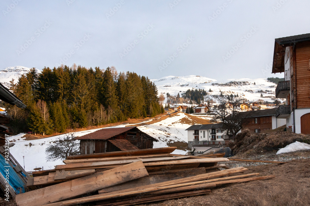 Wooden Barn surrounded by firewood and timber in Obersaxen Mundaun, Graubünden, Switzerland.