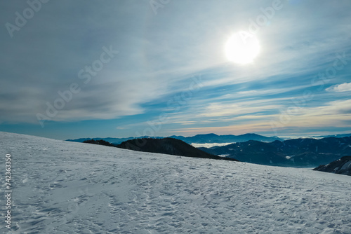 Scenic view of magical snow capped mountain peaks on the way to mount Hochanger, Muerzsteg Alps, Styria, Austria. Ski touring winter wonderland in remote Austrian Alps. Idyllic snowy forest and valley photo