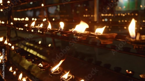 Oil lamps at Buddhist temple. Oil lamp worshipper lighting at stupa. Outdoor night 4k footage. Offering place in Sri Lanka, Hikkaduwa photo