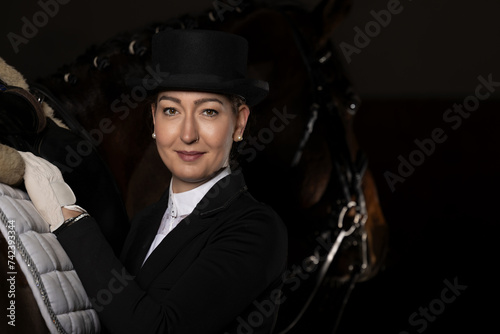Dressage rider head portraits, with top hat next to her horse. © RD-Fotografie