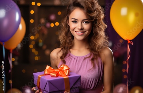 a young woman is holding birthday party present in the background