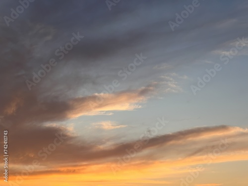 The Dance of Dusk as Clouds Embrace the Warm Glow of a Setting Sun. Beautiful clouds in the sky background. A Symphony of Sunset Colors Painting the Evening Sky with Hues of Orange and Pink