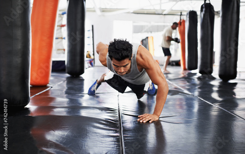 Man, pushups and training for fitness, sport and health for being a boxer on mat with one arm. Male person, wellness and exercise for workout, athlete and cardio strength for commitment in boxing gym © Mariusz/peopleimages.com