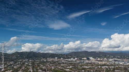 Aerial view of city of Los Angeles cityscape. Hyperlapse zoom in on beautiful clouds rolling over Hollywood Hills.