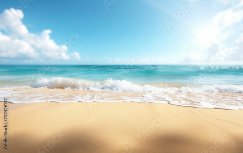 A sandy beach with waves gently rolling in towards the shore under a clear blue sky on a sunny day