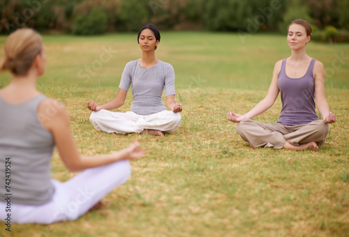 Lotus, group and meditation outdoor for yoga, healthy body and mindfulness exercise to relax. Peace, zen and calm women in padmasana in nature for balance, spirituality or breathing with instructor