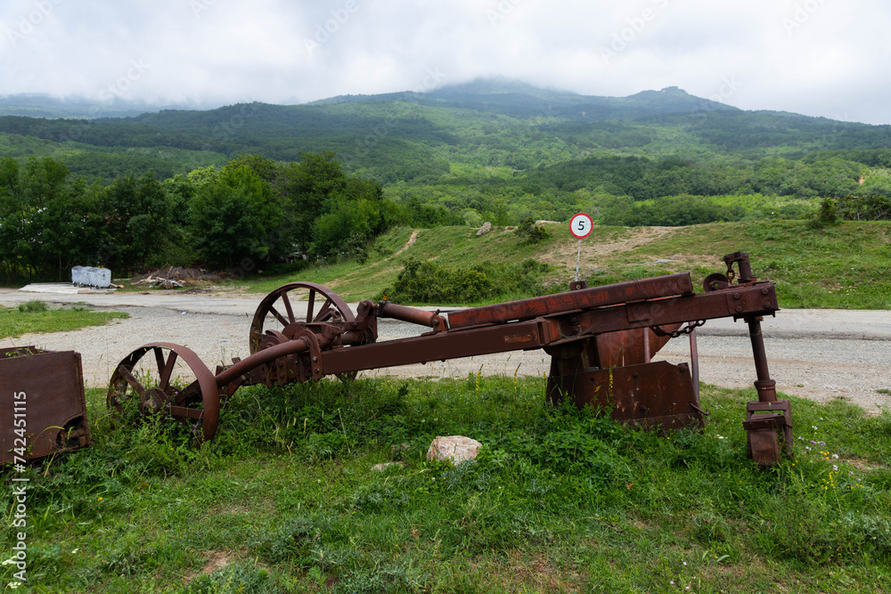 Fototapeta premium An old rusty one-bottomed iron plow for plowing the soil for vineyards.
