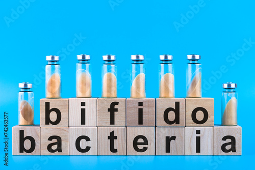 Vials, ampoules with dry probiotic, bifidobacteria, with probiotic powder inside on a blue background. Copy space. photo