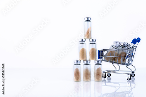 Vials, ampoules with dry probiotic, bifidobacteria inside, in the shopping cart. against the background of belrm. Copy space. photo