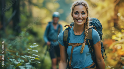 Smiling woman hiking in the forest with companion in the background. Outdoor adventure and leisure activity concept photo
