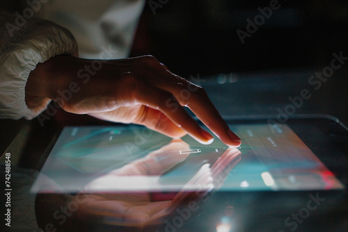 artistic shot of a student's hand reaching out to touch a tablet screen displaying interactive e-learning modules, shot from hiding camera, minimalistic style,