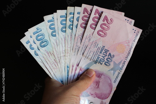 Fototapeta Naklejka Na Ścianę i Meble -  man counting Turkish money with his hand. Turkish lira banknotes. The paper currency of Turkey. Current Turkish liras are issued by The Central Bank of the Republic of Turkey. 