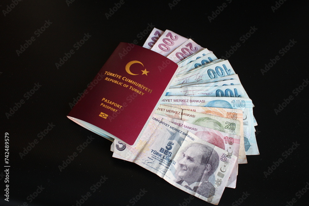 Turkish banknotes in Turkish passport.The paper currency of Turkey. Current Turkish liras are issued by The Central Bank of the Republic of Turkey. Turkish banknotes in Turkish passport.The paper currency of Turkey. Current Turkish liras are issued by The Central Bank of the Republic of Turkey.