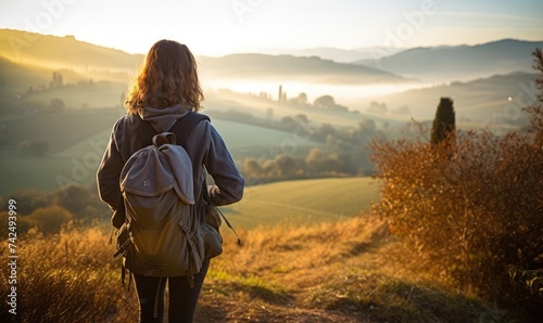 Tuscan Serenity: Against the Backdrop of a Tuscan Sunset, a Woman Tourist Walking at the Lush Fields, Captivated by Tuscany's Timeless Splendor.	
