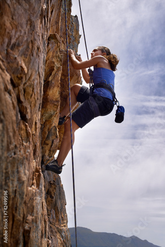 Woman, mountain and rock climbing for hiking in outdoors, challenge and rope for training. Female person, cliff and extreme sport for exercise or workout, adventure and support to explore in nature