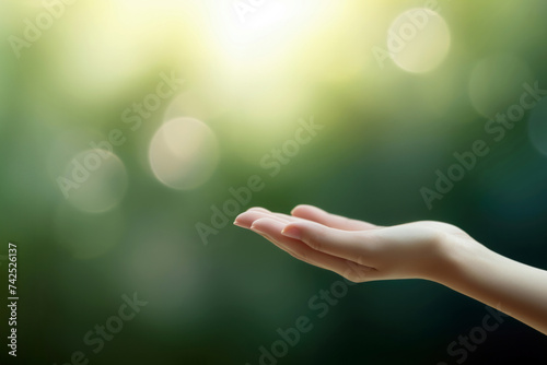 Close up of female hand open with bokeh effect on nature background. High quality photo