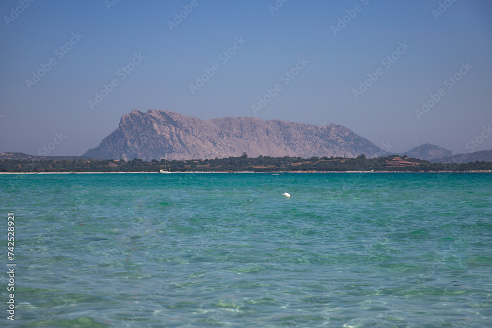 Turquoise sea water and Tavolara Island view in La Cinta Beach in San Teodoro, Sardinia, Italy Turquoise sea water and Tavolara Island view in La Cinta Beach in San Teodoro, Sardinia, Italy