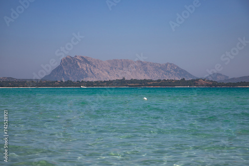 Turquoise sea water and Tavolara Island view in La Cinta Beach in San Teodoro, Sardinia, Italy 