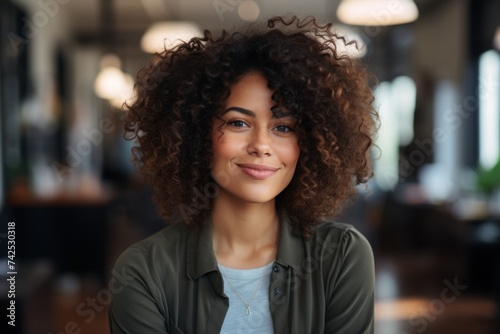 Portrait of a professional woman in a suit standing in a modern office. Mature business woman looking at the camera in a workplace meeting area.