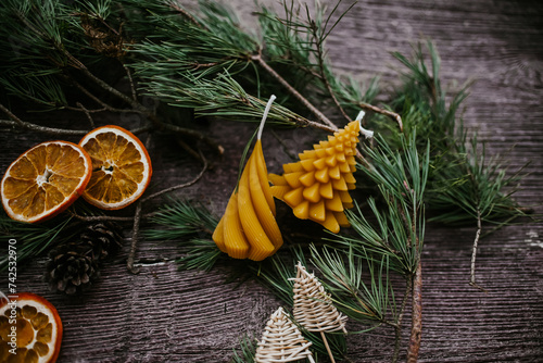 Christmas decoration, bees wax candle, dried orange slices and handmade Christmas tree ornament on wooden background