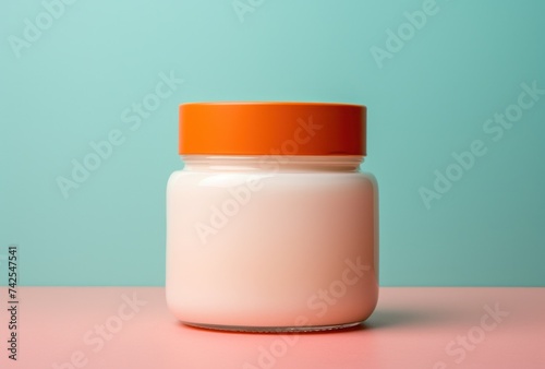 a jar of cream sitting on a pink background