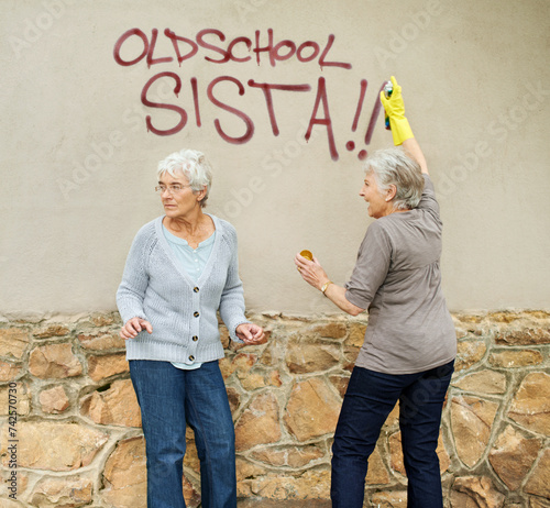 Senior women, graffiti or spray painting a wall, looking or vandalism for fun, trouble or humor. Elderly people, together or outdoor by damage to property, friends or retired with can, art or glove